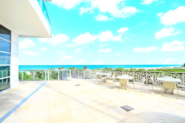 view of patio featuring a view of the beach and a water view