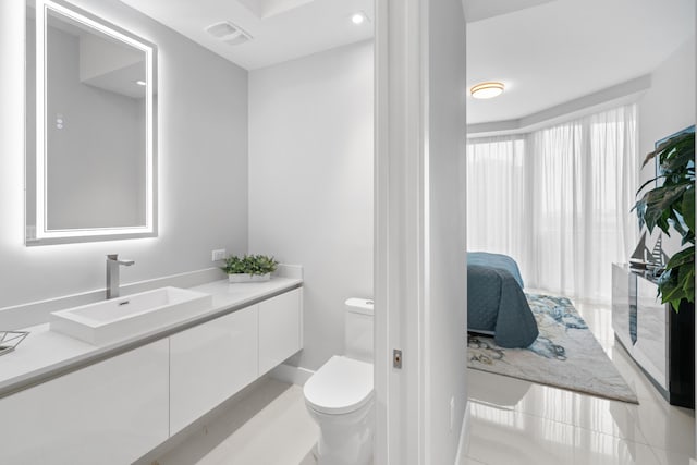 3100 N Ocean Dr Unit H-1508, Singer Island, FL 33404 - ensuite bathroom with toilet, vanity, and tile patterned floors