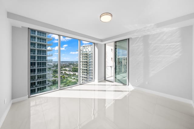 3100 N Ocean Dr Unit H-1508, Singer Island, FL 33404 - tiled empty room with a city view and baseboards