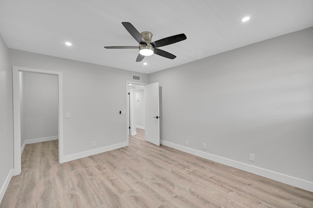 unfurnished bedroom featuring ceiling fan, a walk in closet, and light hardwood / wood-style flooring