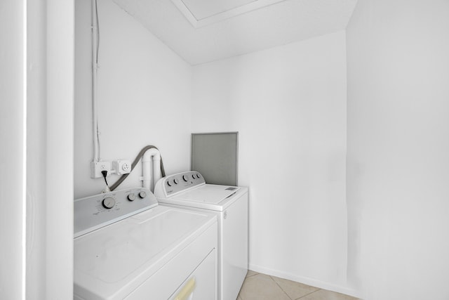 laundry area with washer and clothes dryer, light tile patterned flooring, and a textured ceiling