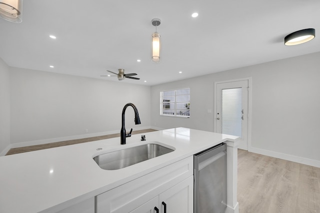 kitchen with ceiling fan, hanging light fixtures, sink, white cabinetry, and light hardwood / wood-style floors