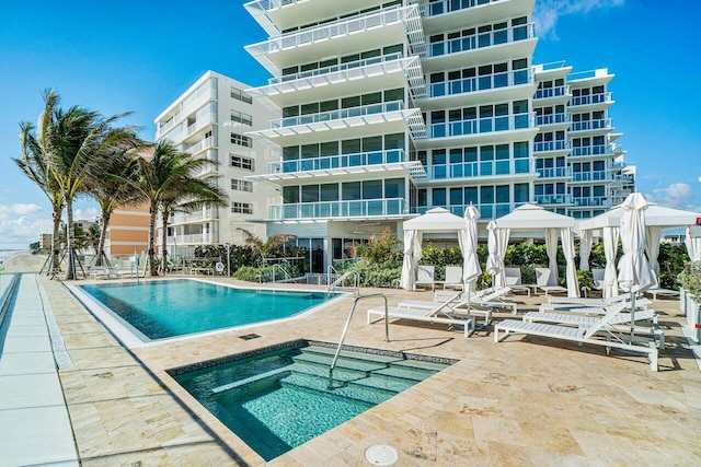 view of swimming pool featuring a community hot tub and a patio area