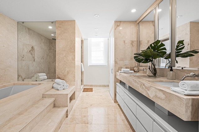 bathroom with vanity, independent shower and bath, and tile walls