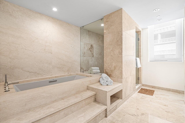 bathroom featuring tile walls and plus walk in shower