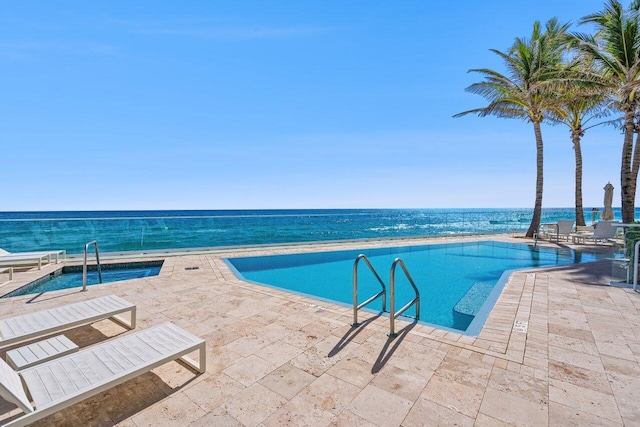 view of swimming pool featuring a patio and a water view