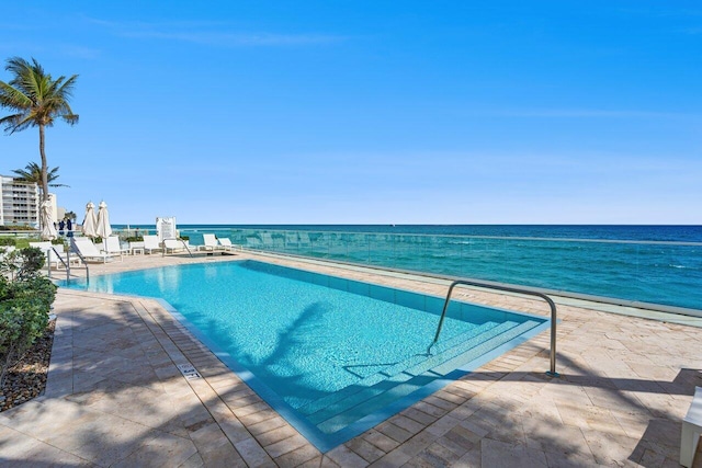 view of swimming pool with a water view and a patio area