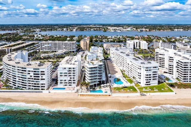 birds eye view of property featuring a water view and a beach view