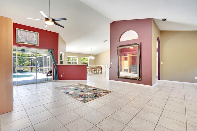 interior space with visible vents, ceiling fan with notable chandelier, high vaulted ceiling, and baseboards