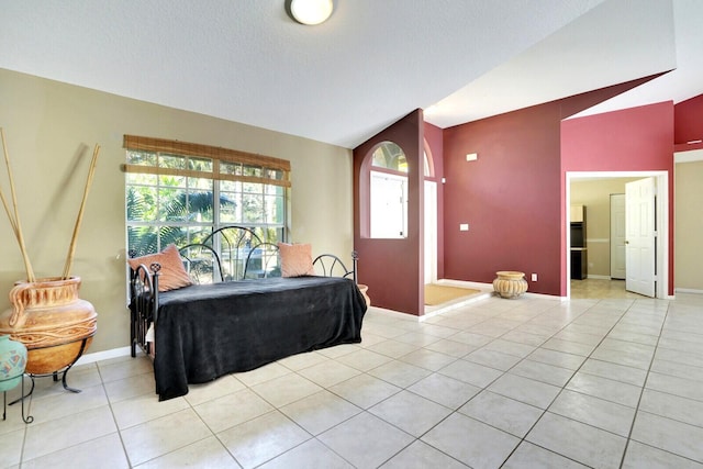 bedroom featuring vaulted ceiling, light tile patterned floors, baseboards, and a textured ceiling