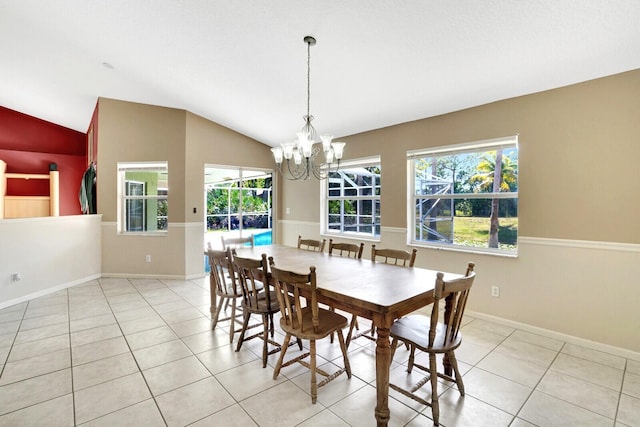 tiled dining area featuring an inviting chandelier, baseboards, and vaulted ceiling