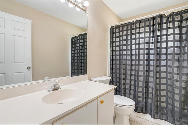 bathroom featuring vanity, tile patterned floors, curtained shower, and toilet