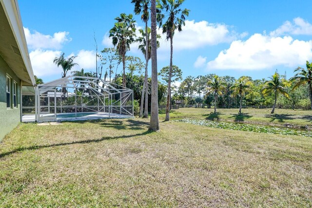 view of yard with glass enclosure