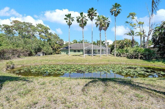 view of yard with a lanai and a water view