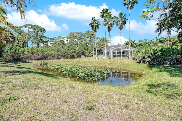 view of yard featuring glass enclosure and a water view