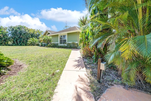 view of front of home with stucco siding and a front lawn