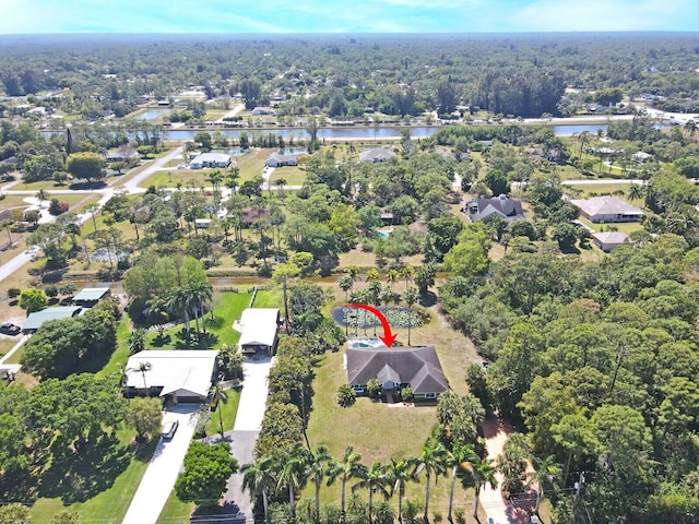 drone / aerial view featuring a wooded view and a water view