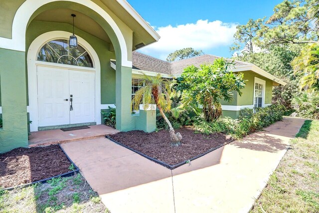 doorway to property featuring stucco siding