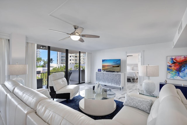 living room featuring ceiling fan and a wall of windows