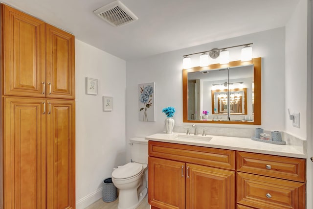 bathroom featuring a notable chandelier, vanity, and toilet