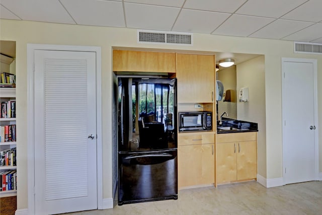 kitchen with a paneled ceiling, sink, and black appliances