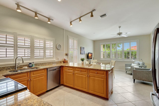 kitchen featuring ceiling fan, sink, kitchen peninsula, track lighting, and stainless steel appliances