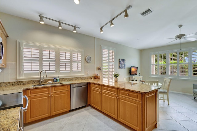 kitchen with ceiling fan, sink, kitchen peninsula, track lighting, and stainless steel appliances