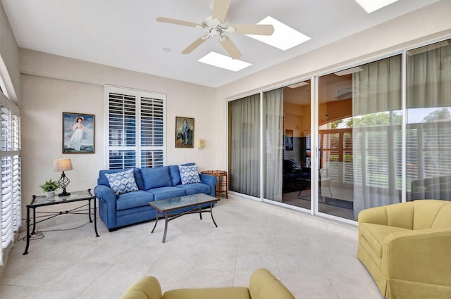 tiled living room featuring ceiling fan and a skylight