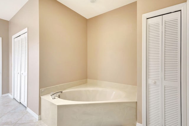 bathroom with tile patterned flooring and a bath