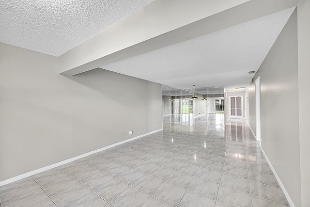 tiled empty room with a textured ceiling