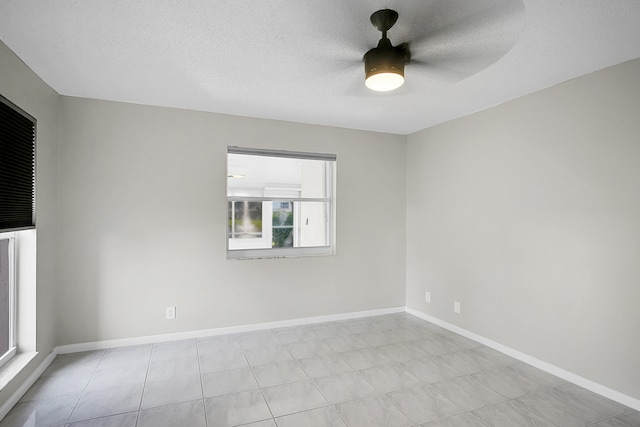 unfurnished room with ceiling fan and a textured ceiling