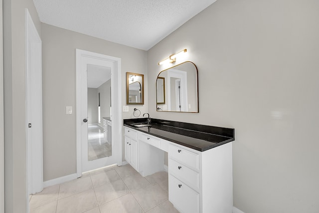 bathroom with tile patterned floors, a textured ceiling, and vanity