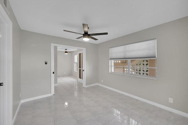 tiled empty room featuring ceiling fan