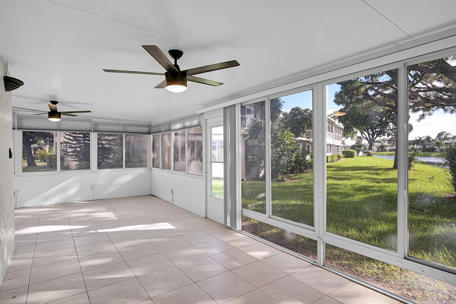 unfurnished sunroom featuring ceiling fan and a wealth of natural light