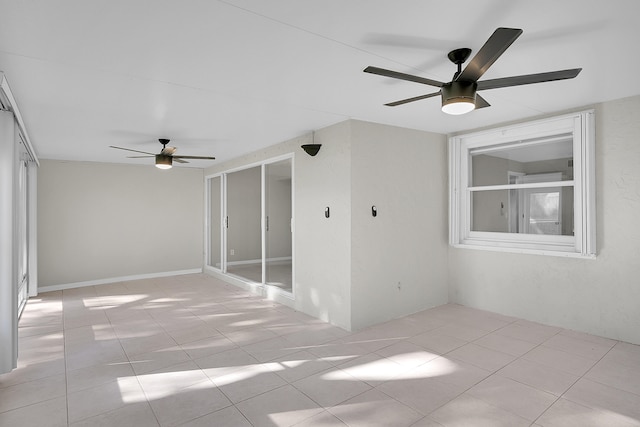 tiled spare room with ceiling fan