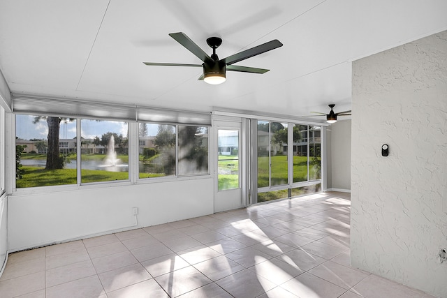 unfurnished sunroom with a water view, ceiling fan, and plenty of natural light