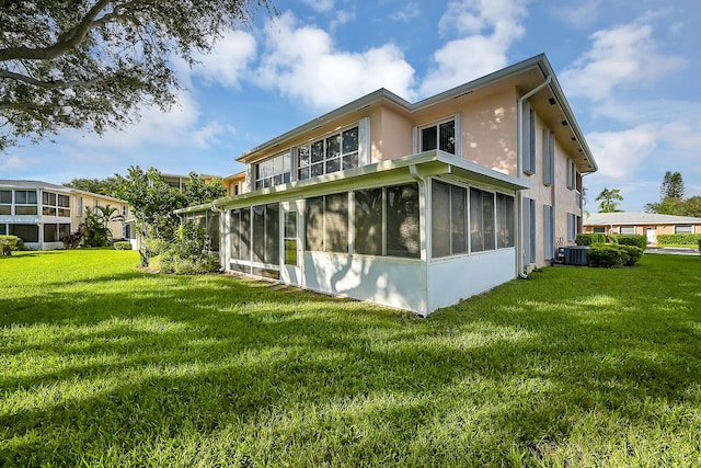 view of property exterior with a sunroom, central AC, and a lawn