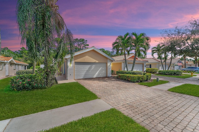 ranch-style house featuring a yard and a garage