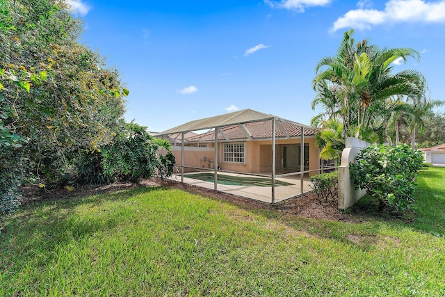 back of house with a lawn, a lanai, and a patio