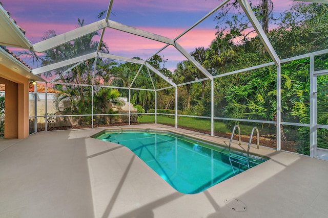 pool at dusk featuring glass enclosure and a patio