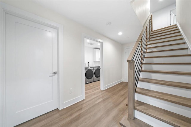 stairs featuring separate washer and dryer and hardwood / wood-style flooring