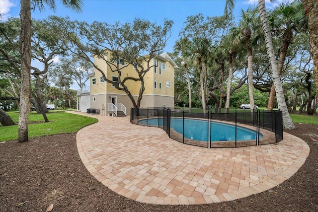 view of pool featuring a lawn, fence, a fenced in pool, and a patio area
