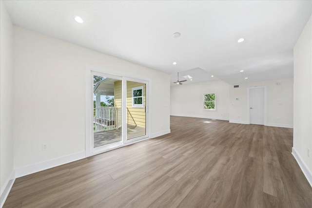 unfurnished room with baseboards, recessed lighting, wood finished floors, and a wealth of natural light