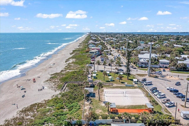 birds eye view of property with a water view and a beach view