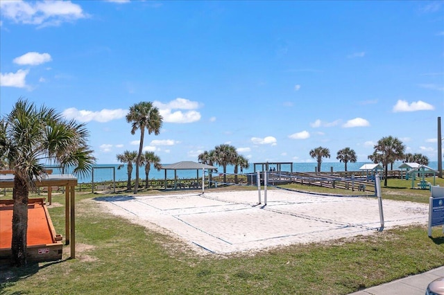 view of property's community with a water view, a yard, and volleyball court