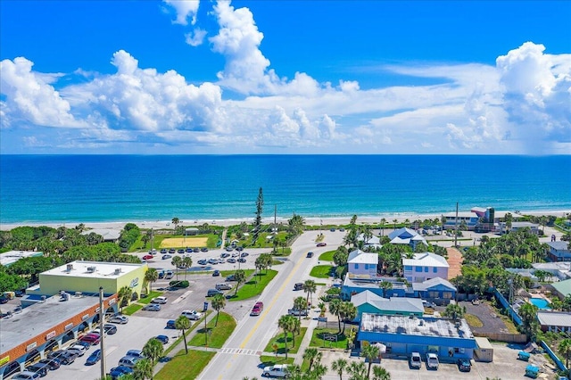 birds eye view of property with a water view and a beach view