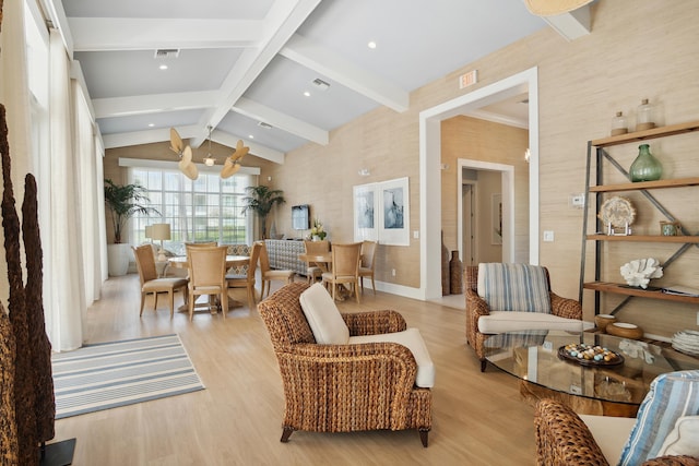 living area with visible vents, vaulted ceiling with beams, and light wood-type flooring