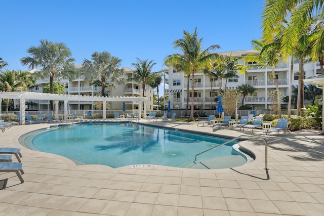 community pool with a patio area and fence