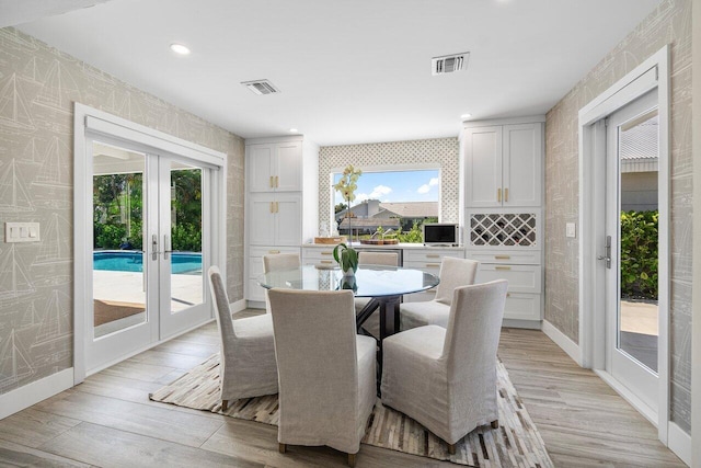 dining space featuring french doors and light hardwood / wood-style flooring