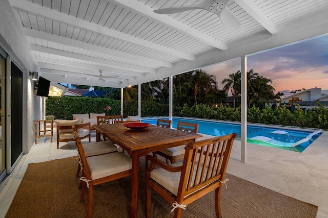 pool at dusk with ceiling fan, a patio area, and a jacuzzi